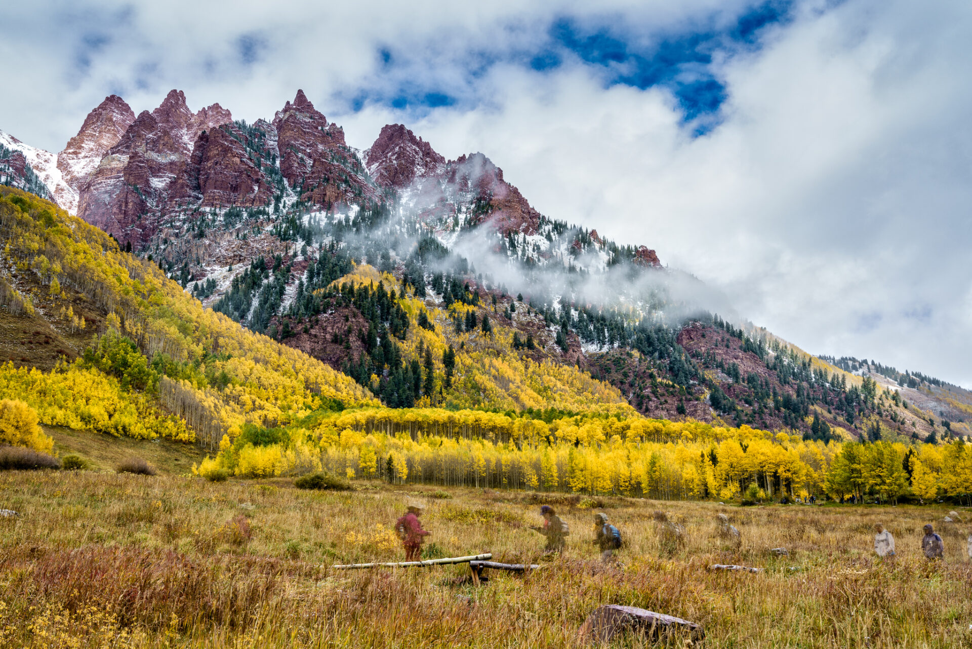 Ghost Hikers and Fall Colors beneath Wintry Peaks near Maroon Bells
